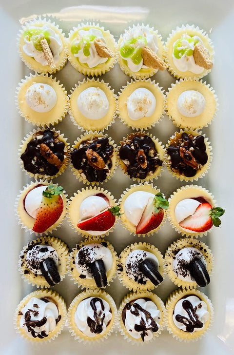 Assorted mini cupcakes with different fillings on a white tray