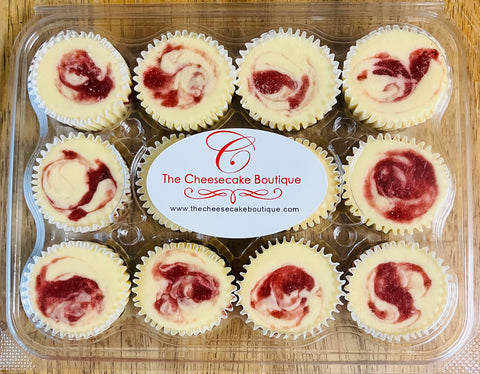 A closed clear clamshell package containing one dozen strawberry swirl cheesecake minis