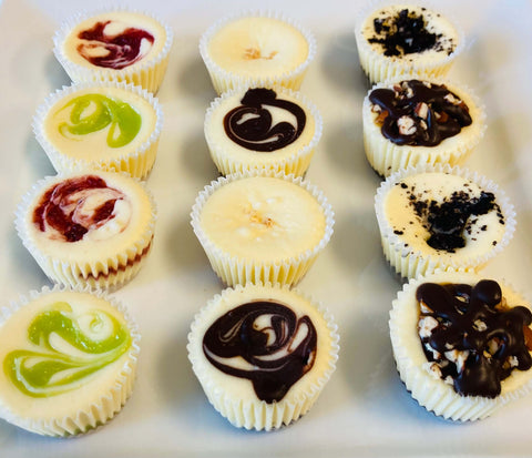 One dozen signature cheesecake minis on a white plate, side view