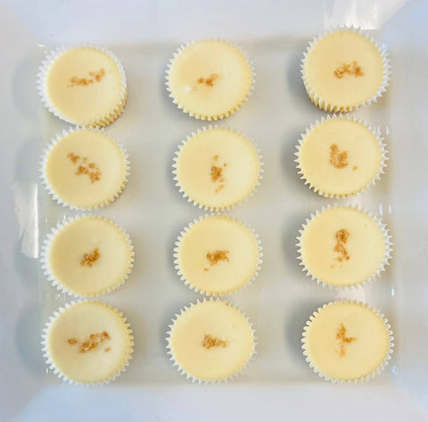 One dozen original classic cheesecake minis arranged on a white plate