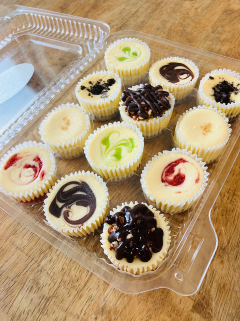 A dozen signature cheesecake minis packaged in a clear, white container