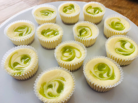 One dozen key lime cheesecake minis arranged on a white, circular platter