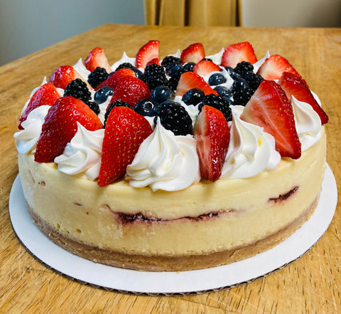 Side view of close-up berry medley whole cheesecake on a table