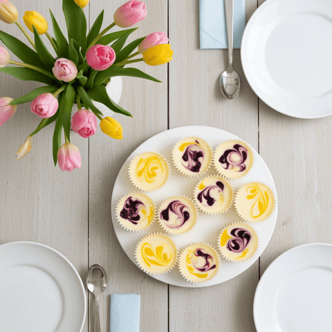 assortment of spring-themed cheesecake minis on a white platter on a wooden table