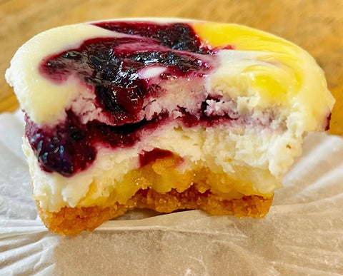 half eaten cheesecake mini with fruit fill on a wooden table