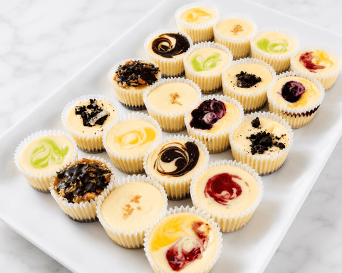 Assorted mini cheesecakes with different fillings on a white plate.