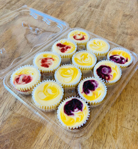 Spring cheesecake minis sitting on a table packaged in an open clamshell for retail sale.
