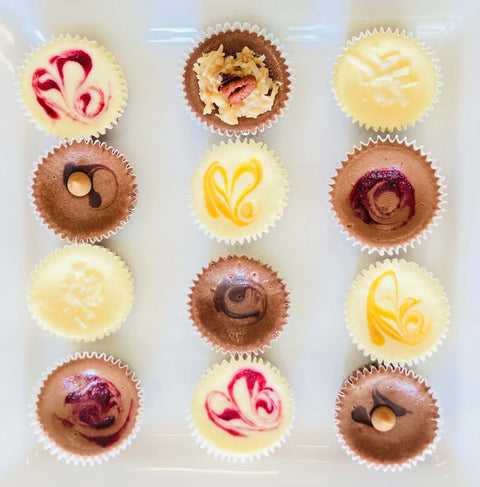 One dozen gourmet chocolate cheesecake minis arranged on a white plate