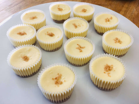 One dozen classic original cheesecake minis arranged in a circle on a white platter