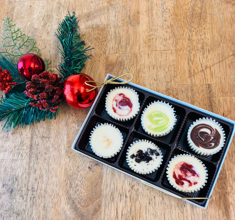 Beautifully packaged Signature Cheesecake Collection gift box with assorted gourmet cheesecake flavors, ideal for holiday gifting and dessert lovers.