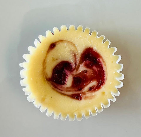 A singular strawberry swirl cheesecake mini against a white background