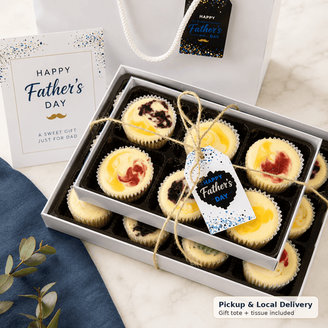 Box of mini cheesecakes with 'Happy Father's Day' tag and gift bag on marble surface