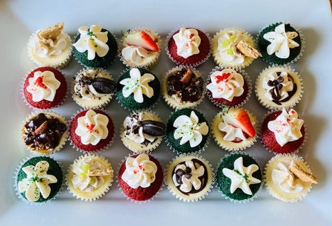 Assorted mini cupcakes and mini cheesecakes with various toppings on a white platter