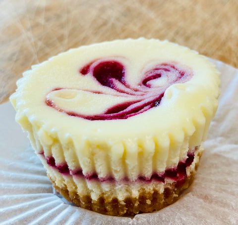 Small cheesecake with raspberry swirl on a white plate