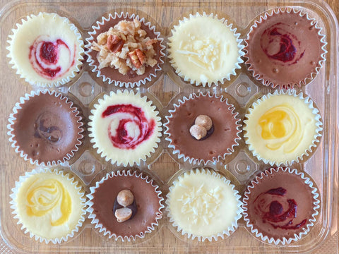 Our signature clam shell packaging with one dozen chocolate cheesecake minis inside.