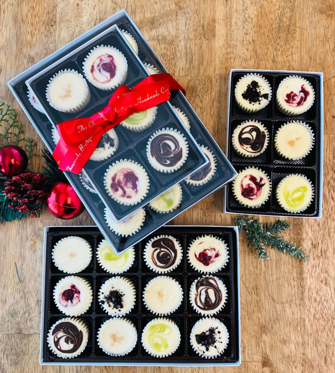 Signature Collection Gift Bundle with 18 mini cheesecakes displayed on a wooden table, featuring The Cheesecake Boutique’s most beloved flavors.