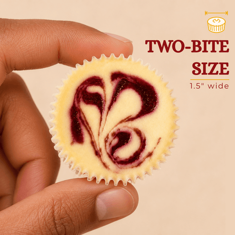 Hand holding a two-bite strawberry swirl cheesecake mini – 1.5 inches wide – from The Cheesecake Boutique