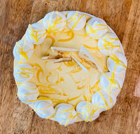 Top down image of the Marbled Lemon Curd whole cheesecake sitting on a wooden table.